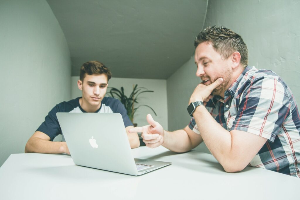 Dois profissionais analisando informações em um notebook